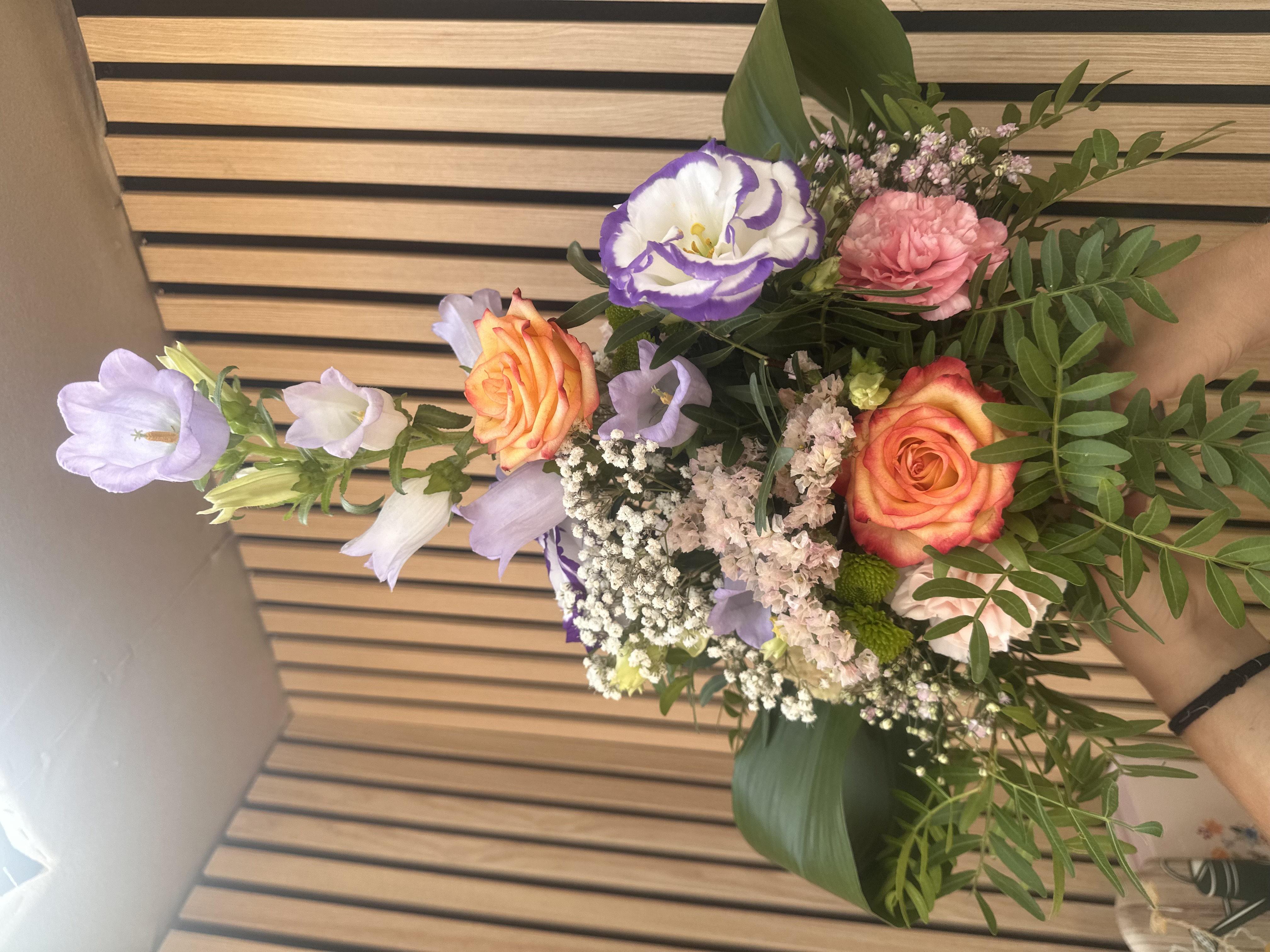 Bouquet Douceur — Une composition élégante et aérienne aux nuances pastel, mêlant roses orangées, campanules, lisianthus et fleurs délicates.