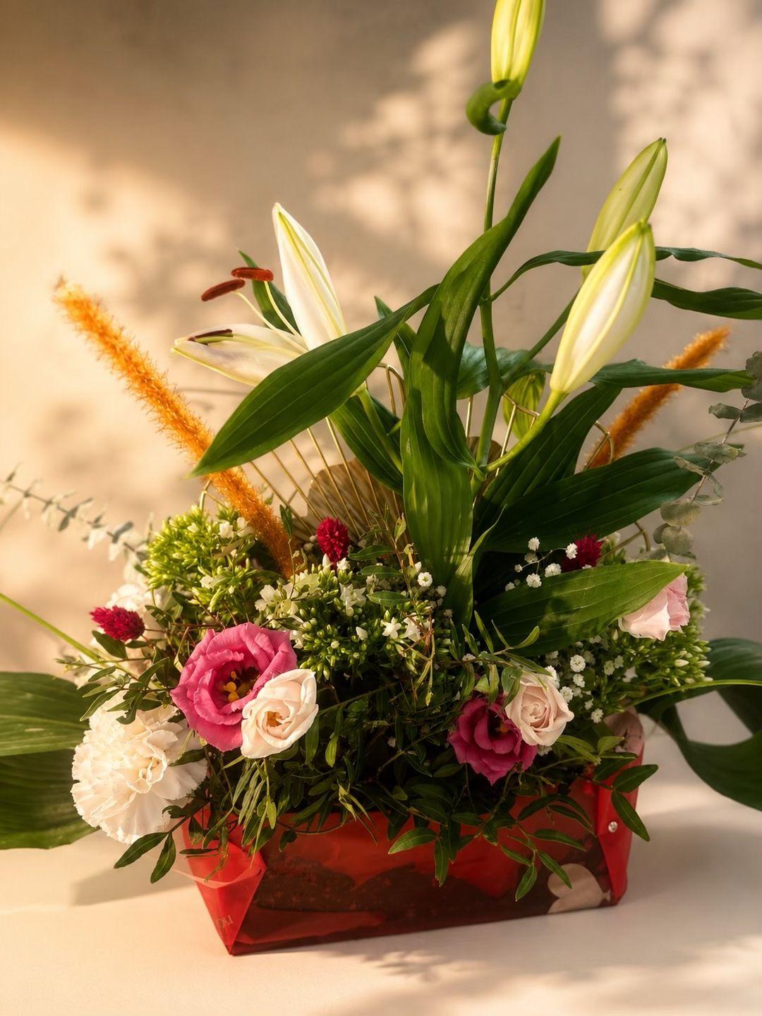 Composition Élégance — Une création florale généreuse et structurée, mêlant lys majestueux, lisianthus roses, œillets et feuillages délicats