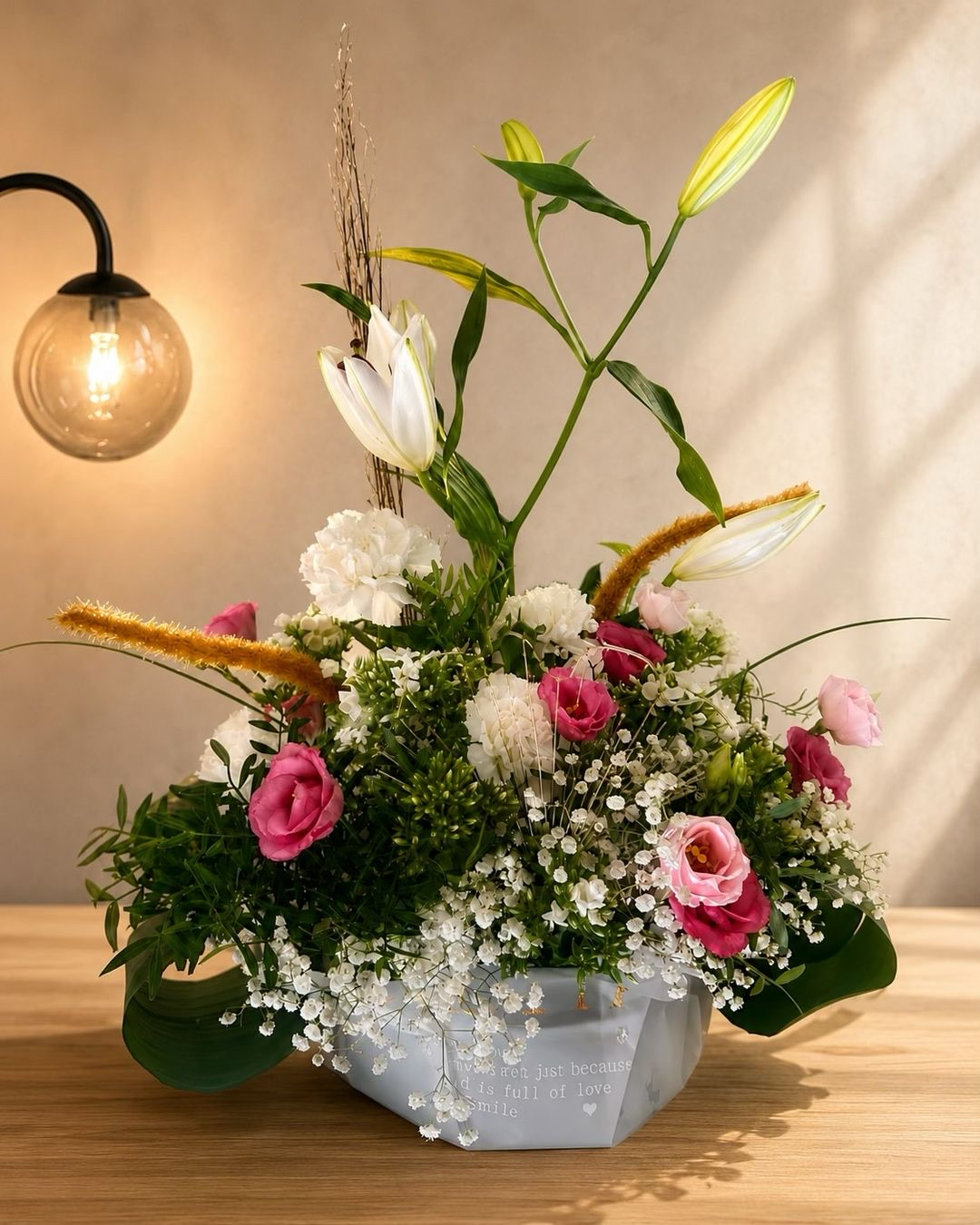 Composition Douce Élégance — Une création florale raffinée et aérienne, mêlant lys blancs, lisianthus roses, œillets et délicat gypsophile