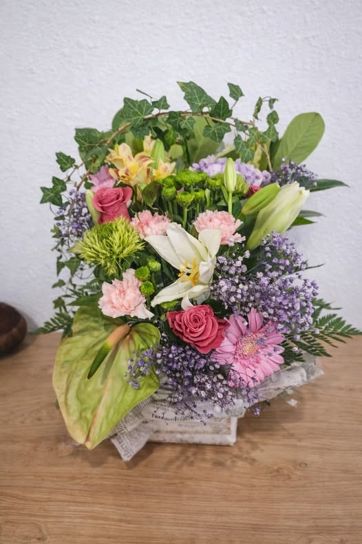 Panier fleuri aux tons roses et violets avec lierre